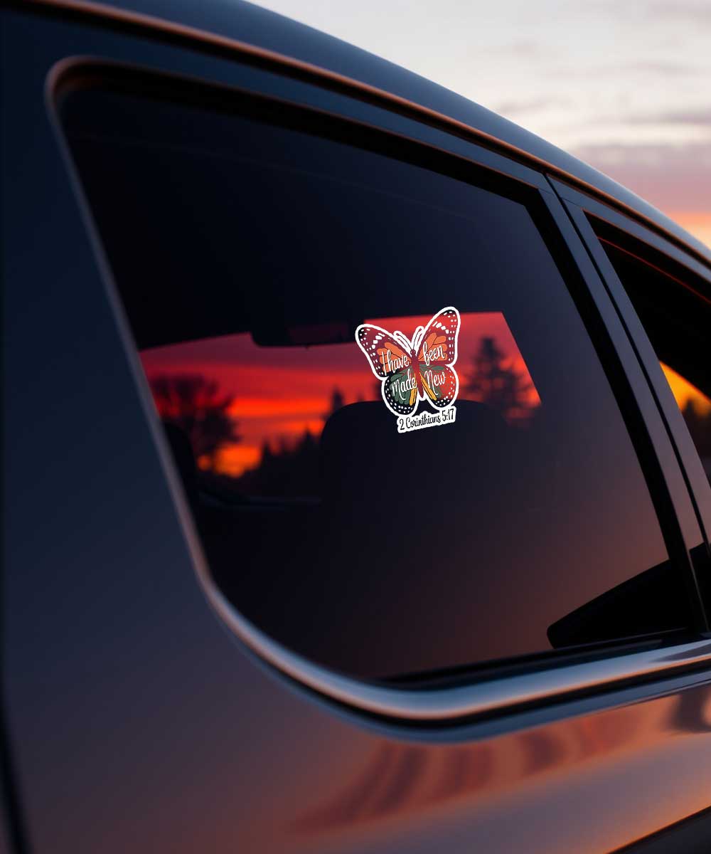 i-have-been-made-new-2-corinthians-5-17-christian-sticker-car-decal "I have been made New 2 Corinthians 5:17" Christian butterfly sticker displayed as a decal on a car window during sunset.
