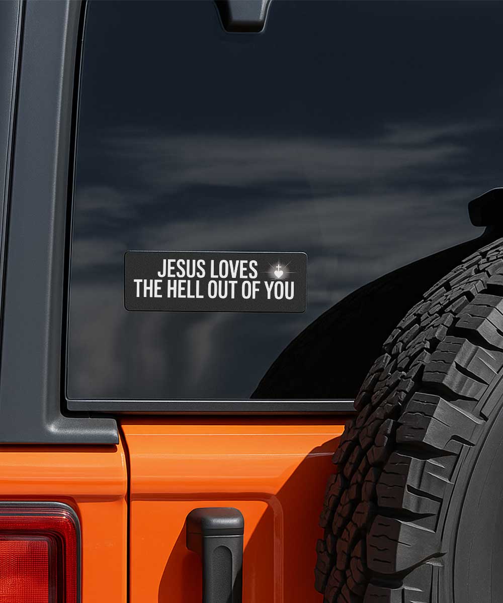 Jesus Loves The Hell Out of You bumper sticker for cars applied to the glass window of an orange vehicle