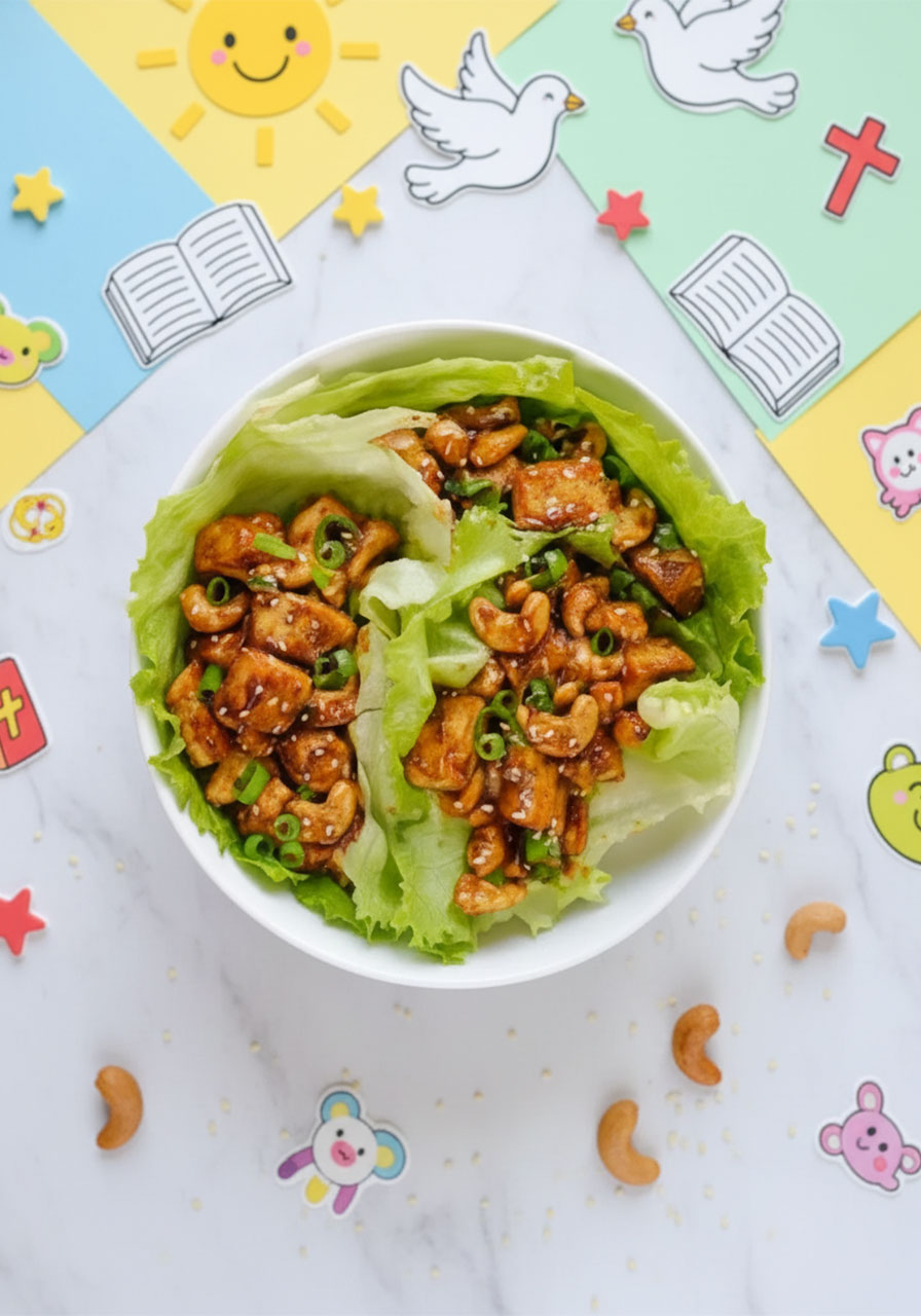 Overhead view of cashew tofu lettuce wraps in a white bowl garnished with green onions and sesame seeds