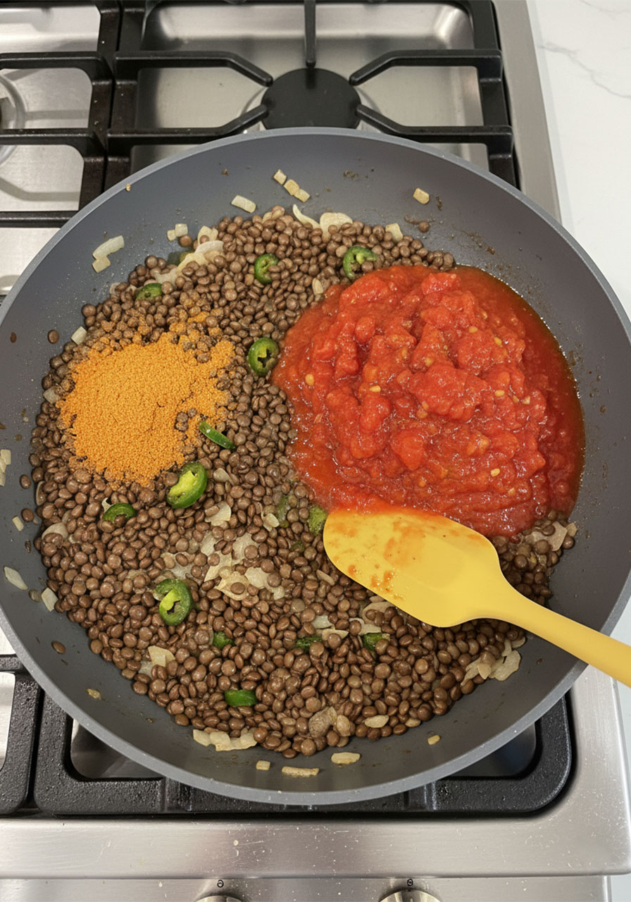 Vegan lentil taco filling with fire-roasted tomatoes and taco seasoning cooking in a pan